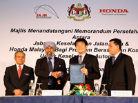 Datuk Suret Singh exchanging MOU with Atsushi Fujimoto witnessed by Dato' Haji Zakaria and Azman Idris.