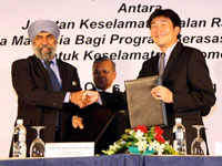 Datuk Suret Singh exchanging MOU with Atsushi Fujimoto witnessed by Dato' Haji Zakaria.