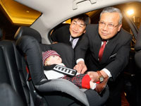 Dato' Haji Zakaria fastening the Honda child seat wtih Atsushi Fujimoto.