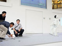 ASIMO plays futsal with one of the online contest winner.