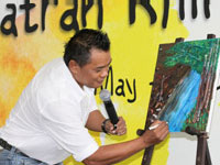 Encik. Zainal Abidin autographing his art piece during the Rhino Essay and Photo Contest prize giving ceremony.