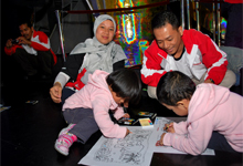 Children coloring their art piece while parents looked on.